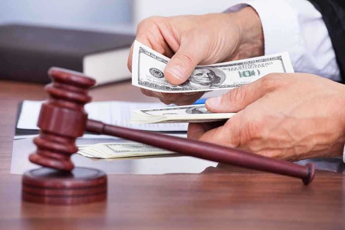 shutterstock_172062569 A person counting cash in a courtroom setting with a gavel in the foreground