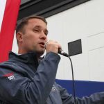 Socialism Panic Hits Virginia Again Man speaking into a microphone at an outdoor event