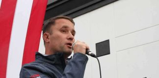 Man speaking into a microphone at an outdoor event