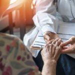 Clinic Records vs Ambulance: Who’s Lying? A doctor holding the hand of an elderly patient during a consultation