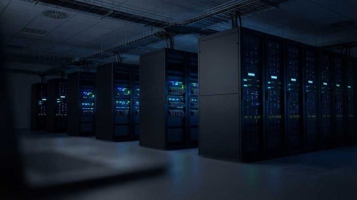 shutterstock_2724815079 Rows of illuminated server racks in a dark data center