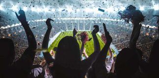 Fans cheering in a packed stadium during a night game