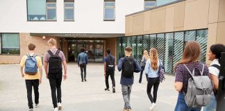 Students with backpacks walking toward a school entrance