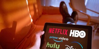 Person holding a tablet showing streaming service logos