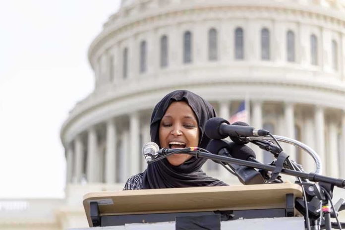 Woman in hijab speaking at podium with microphones