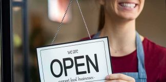 Shop worker holding an open sign