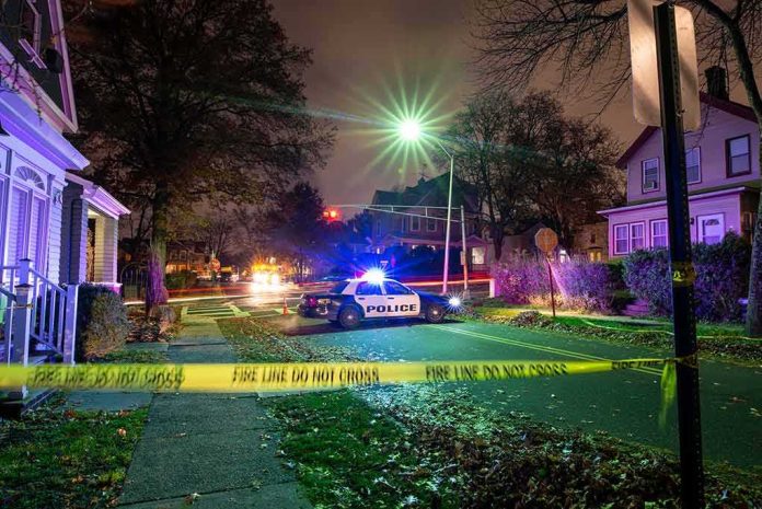 shutterstock_1793905801 Police car blocks residential street at night behind caution tape