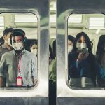 Commuters wearing masks inside a crowded subway train
