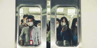 Commuters wearing masks inside a crowded subway train