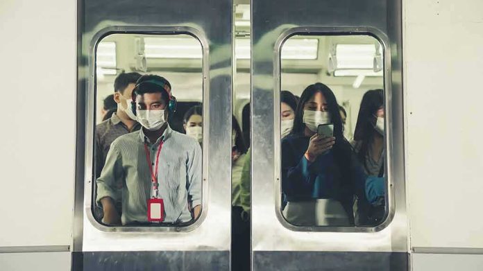 shutterstock_1851038077 Commuters wearing masks inside a crowded subway train