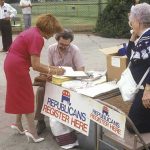 People at an outdoor voter registration table