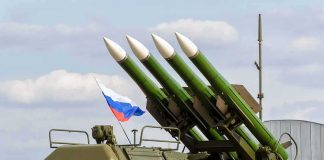 Surface-to-air missile launcher with green rockets and a raised Russian flag