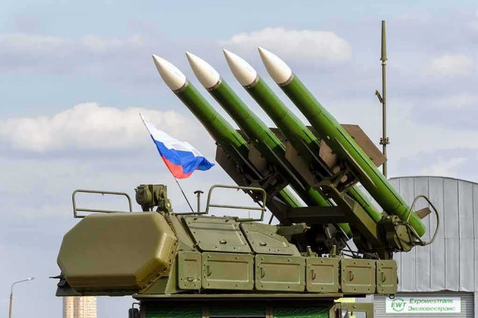 Surface-to-air missile launcher with green rockets and a raised Russian flag