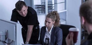 Police officers reviewing documents at a desk