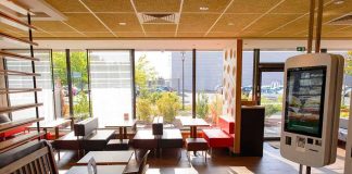 Fast-food restaurant interior with self-order kiosk and seating