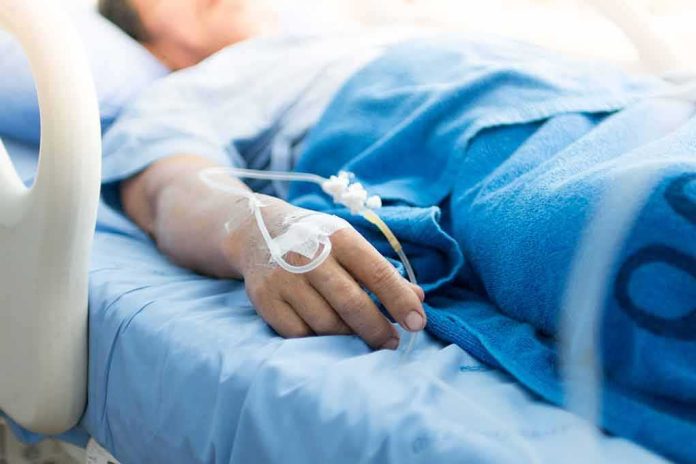 Patient hand with IV line resting on hospital bed