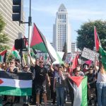 Collective Punishment Or Security Play? Protesters holding Palestinian flags gather in a city street