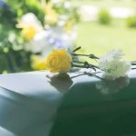 Autopsy Countdown After Rehab Death Yellow rose and white carnation on a green casket