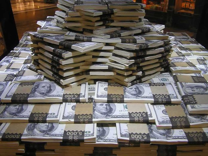 shutterstock_1022028568 Stacks of U.S. hundred-dollar bills arranged in a pyramid