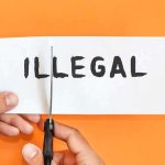 Fleeing Illegal Immigrant Crashes Car Into Mayor’s Wife hands cutting paper with the word illegal