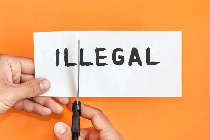 shutterstock_1086185429 hands cutting paper with the word illegal
