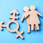 High Court Shuts Door On Women-Only App Wooden transgender symbol and two human figures on blue background