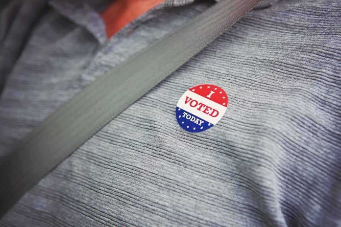 shutterstock_1156344568 I voted sticker on a gray shirt under a seat belt