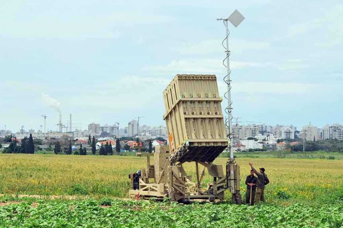 shutterstock_115740022 Military defense system deployed in a field with soldiers nearby
