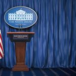 Qatar Jet For Trump Triggers Security Alarm White House press briefing podium with U.S. flag and blue curtain