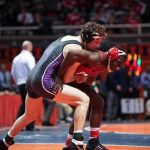 State Law Said 48 Hours. School Waited 53 Days. Caraun Reid in red wrestling an opponent during a college match