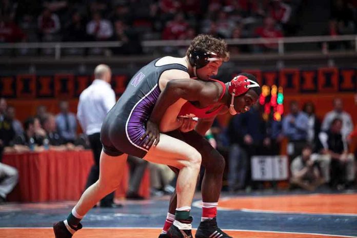 shutterstock_135776582 Caraun Reid in red wrestling an opponent during a college match