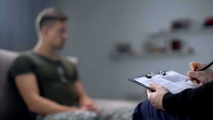 Therapist taking notes while man sits on couch