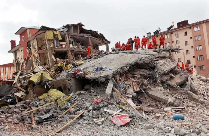 shutterstock_148947701-1 Rescue workers in orange uniforms on a collapsed building site after an earthquake
