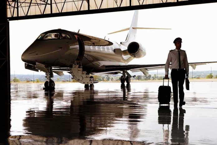 shutterstock_1586690725-1 Pilot walking with suitcase beside private jet in hangar