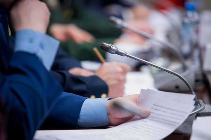 shutterstock_1592903788 Conference microphone on table with hands holding documents