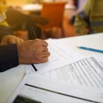 Brutal Drill Leaves NHL Prospect Comatose Worker hand filling out forms on a desk
