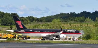Private jet with black and red livery parked on airport tarmac