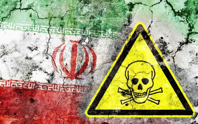 Iran flag on cracked wall with yellow skull and crossbones warning sign