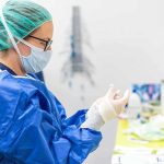 Incurable Diagnosis — One Missed Sign medical professional in blue gown putting on sterile gloves