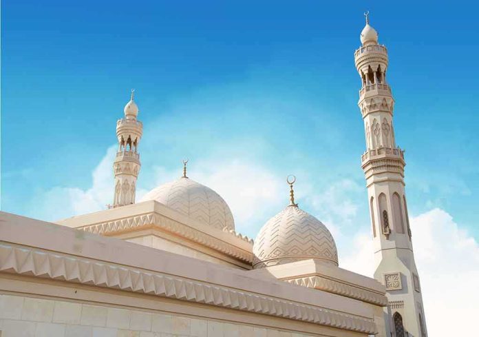 shutterstock_1729676344 Mosque with domes and minarets against a clear blue sky