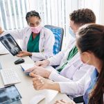 Testosterone Twist Upends Pregnancy Talk Doctors reviewing chest X-ray at a workstation