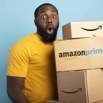 Man in yellow shirt holding stack of Amazon Prime boxes