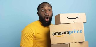 Man in yellow shirt holding stack of Amazon Prime boxes
