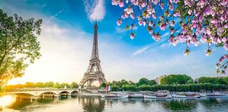 Eiffel Tower by the Seine with boats and spring blossoms