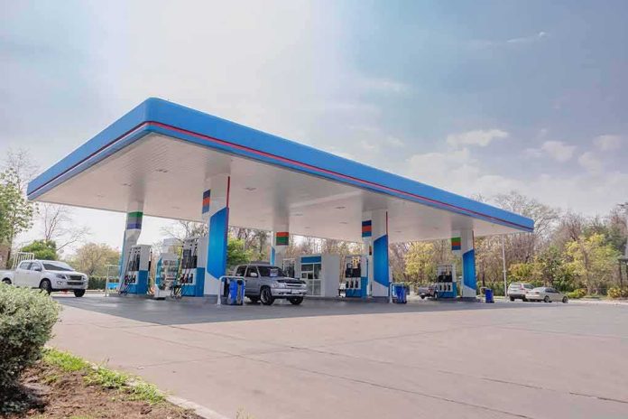 Gas station canopy with multiple fuel pumps and parked cars