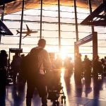 A Beloved Music Legend Could Get An Airport Airport terminal crowd at sunset with airplane silhouette outside