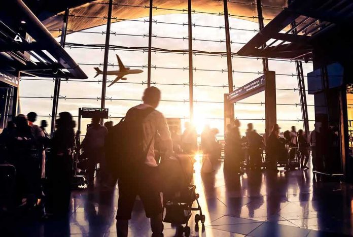 Airport terminal crowd at sunset with airplane silhouette outside