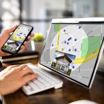 Judge Greenlights Fight—Deal Unravels Person using phone and laptop with real estate map app