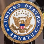 One Defection, Big Trouble For Trump United States Senate seal at a podium