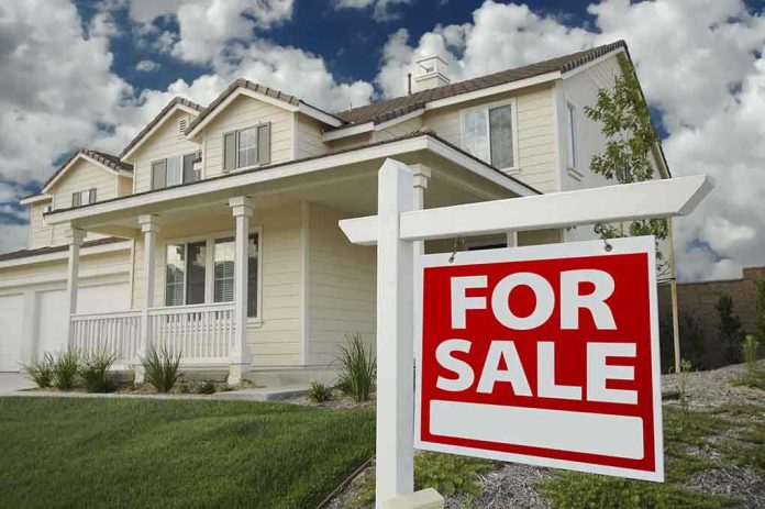 A suburban house with a For Sale sign in the front yard